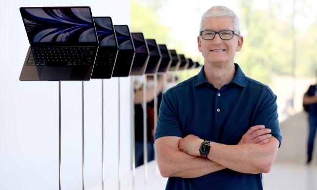 Apple CEO Tim Cook looks at a display of brand new redesigned MacBook Air laptop during the WWDC22