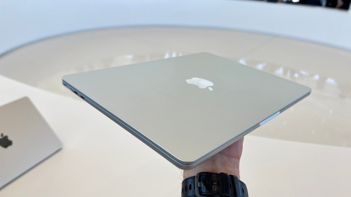 A person holding the M2 MacBook Air in their hand.