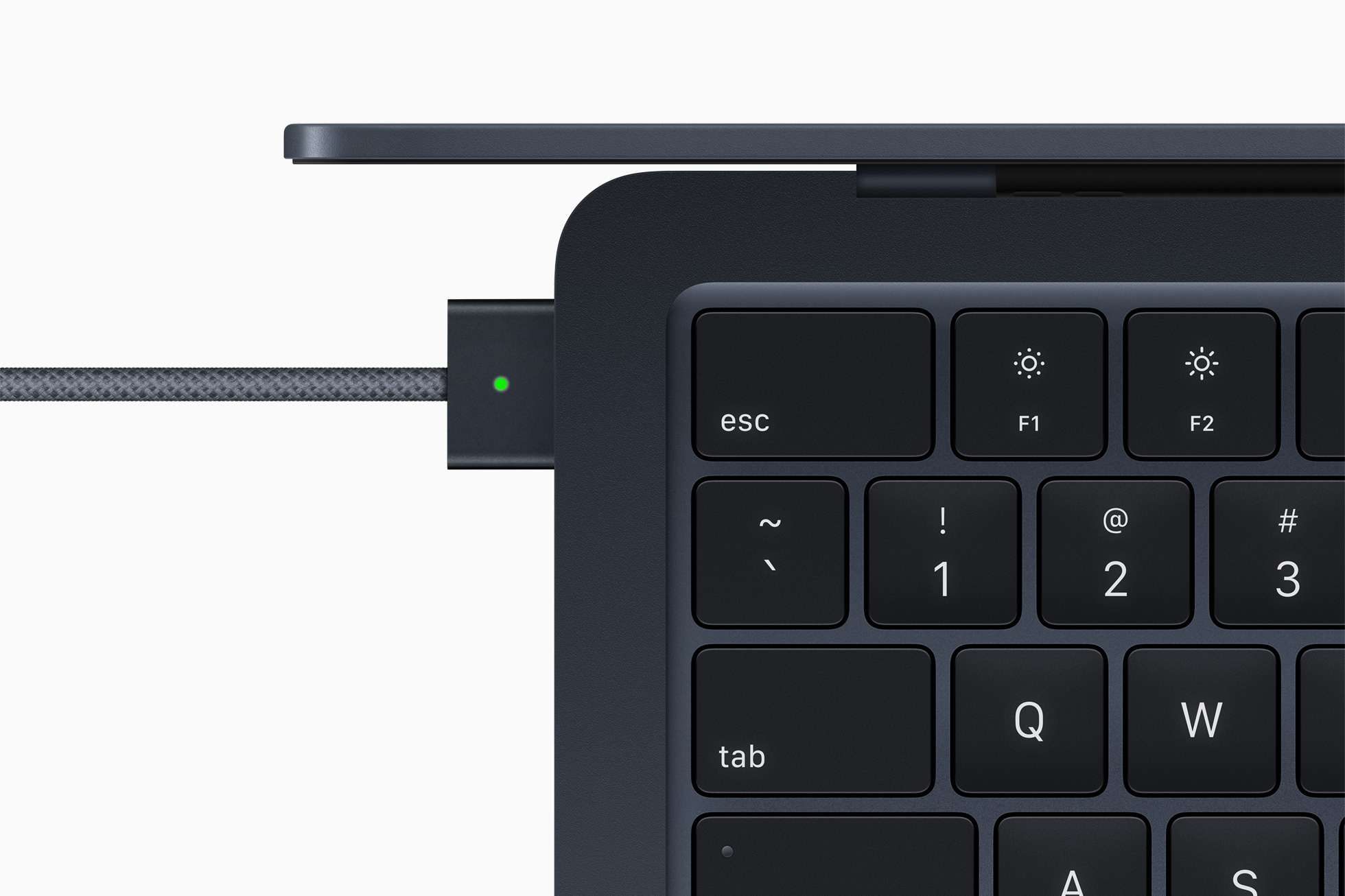 Uma vista superior do MacBook Air M2 mostrando seu teclado e carregador MagSafe.