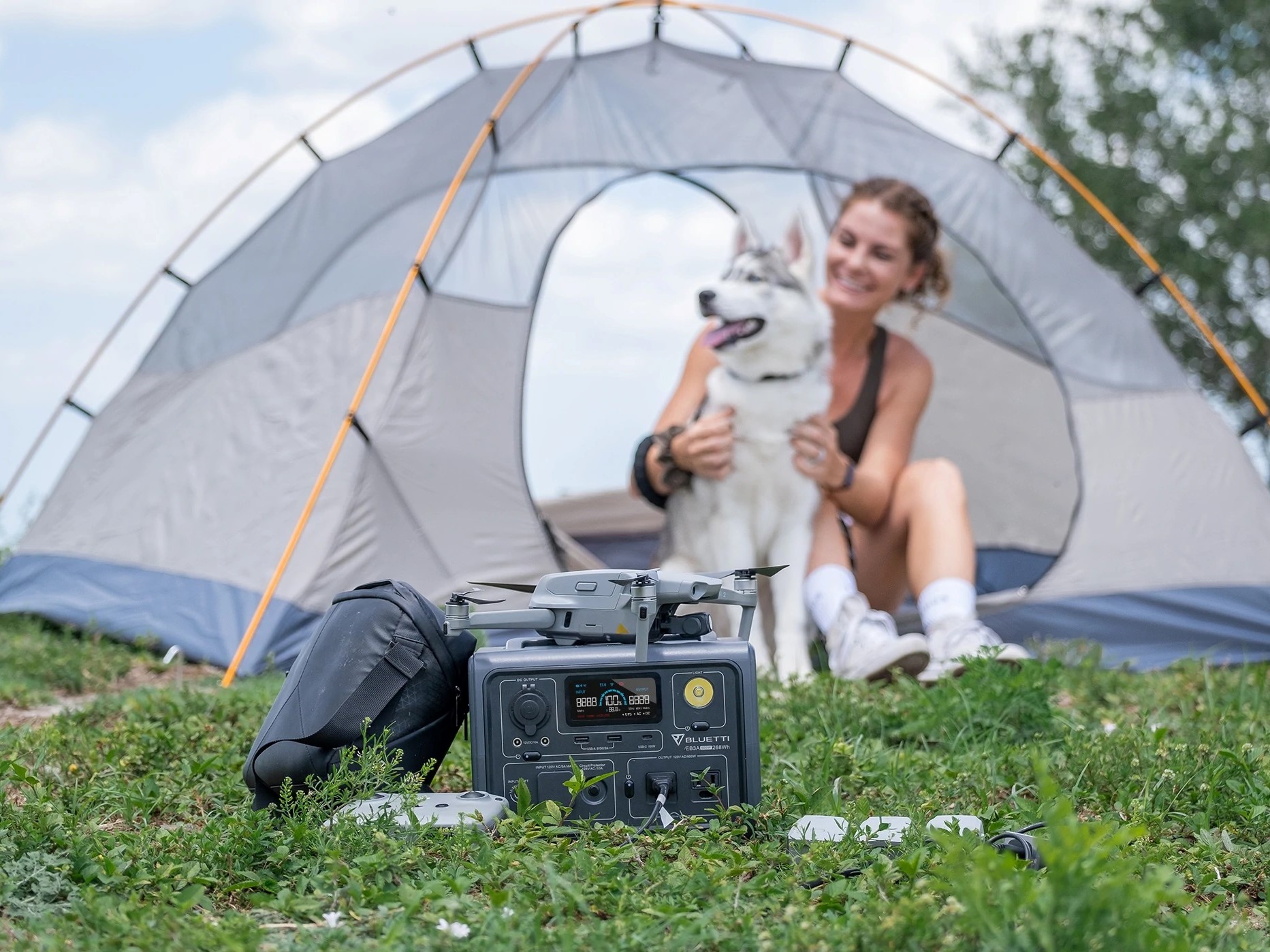 Uma mulher usa Bluetti EB3A usado ao acampar com seu cachorro. 