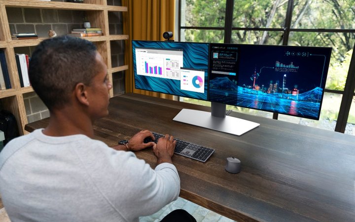 A man sits in front of a large desk as he uses the Dell Precision 7865 Tower.
