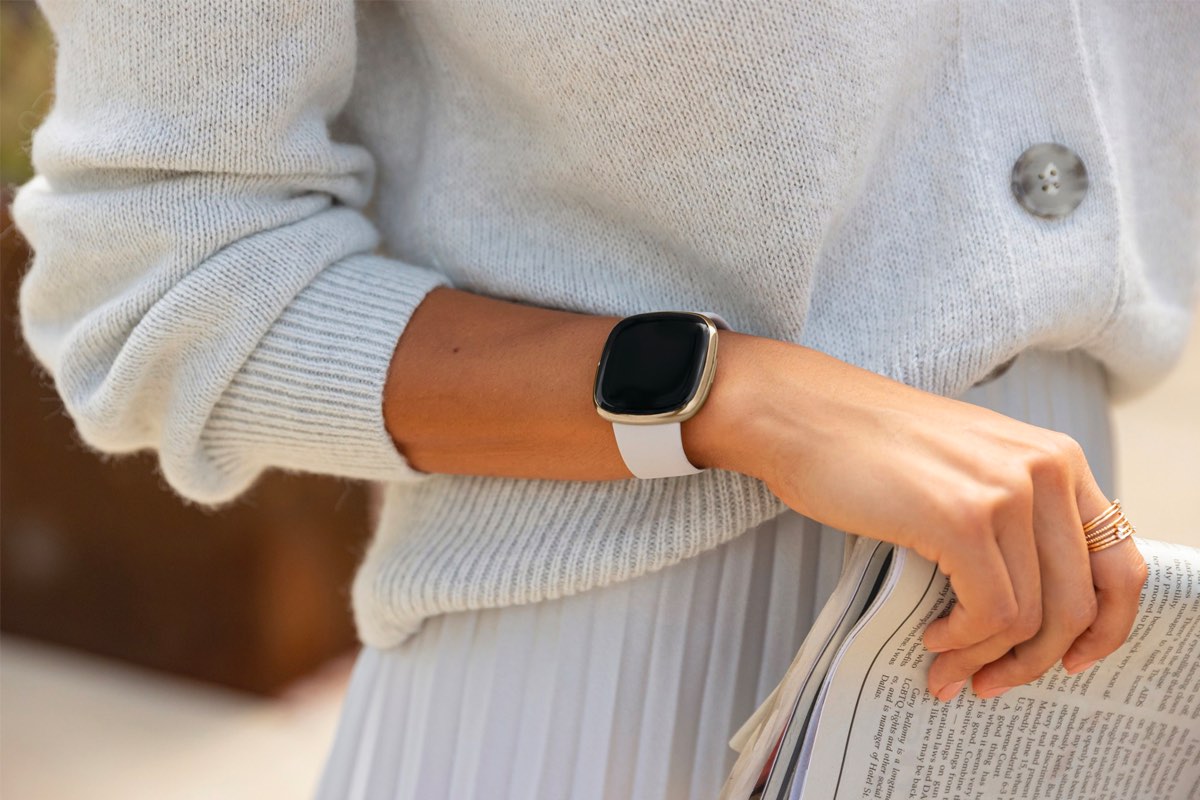 Um close-up do braço de alguém enquanto eles usam um Fitbit Sense.