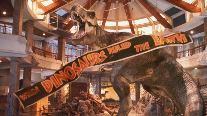 A T-Rex roaring triumphantly as a banner falls in Jurassic Park.