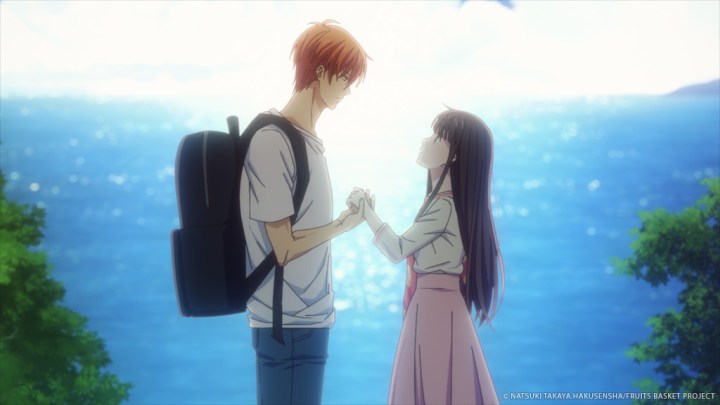 Kyo e Tohru si tengono per mano sullo sfondo dell'oceano scintillante in Fruits Basket -prelude-.
