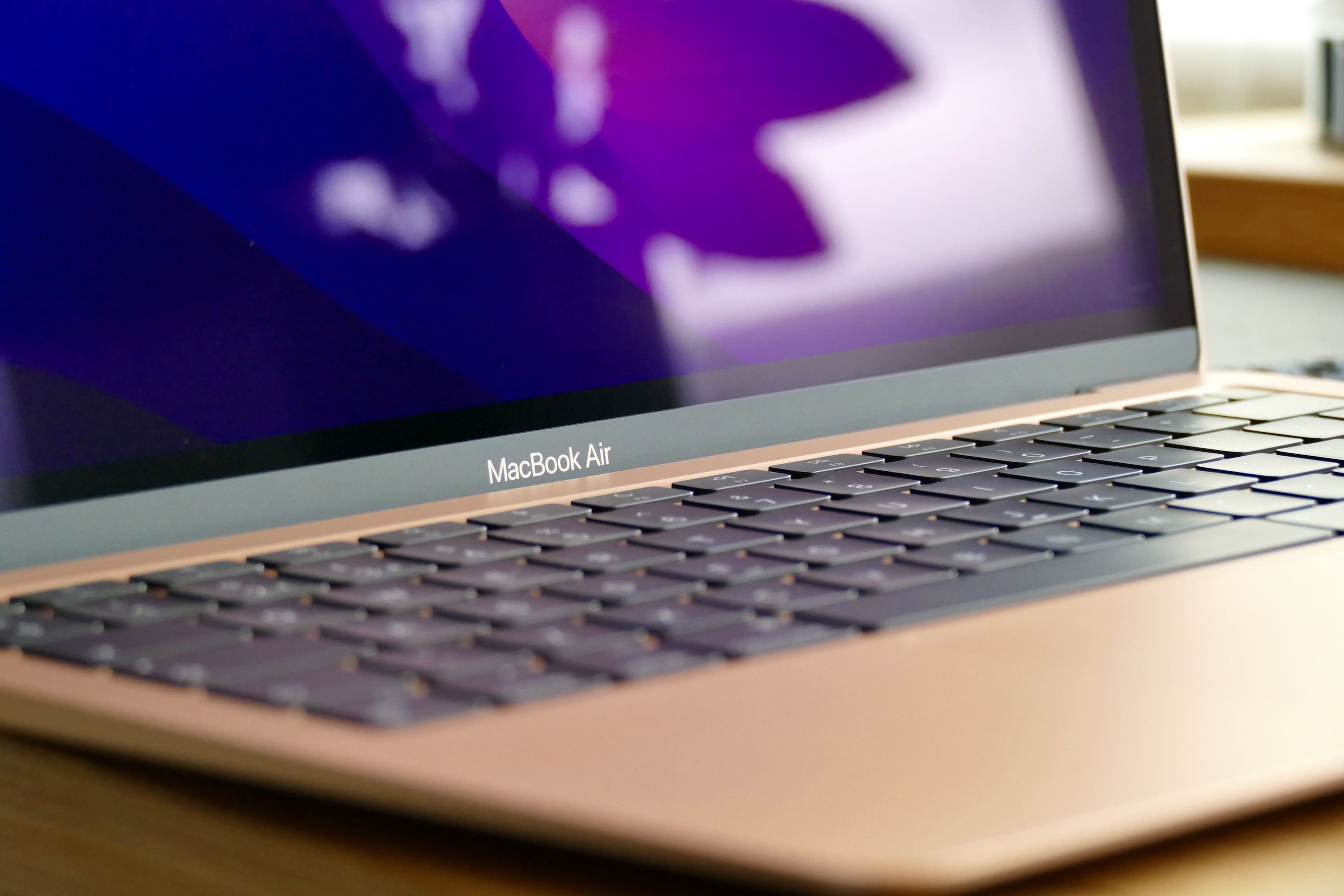 O logotipo e o teclado dourados do MacBook Air M1.