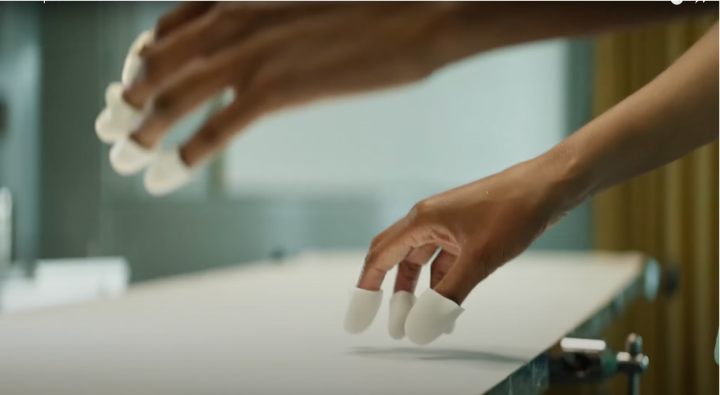 Meta VR fingertip sensors shown on someone's hands.