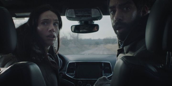 Katie Parker and Rahul Kohli sitting in a car in a scene from Next Exit.