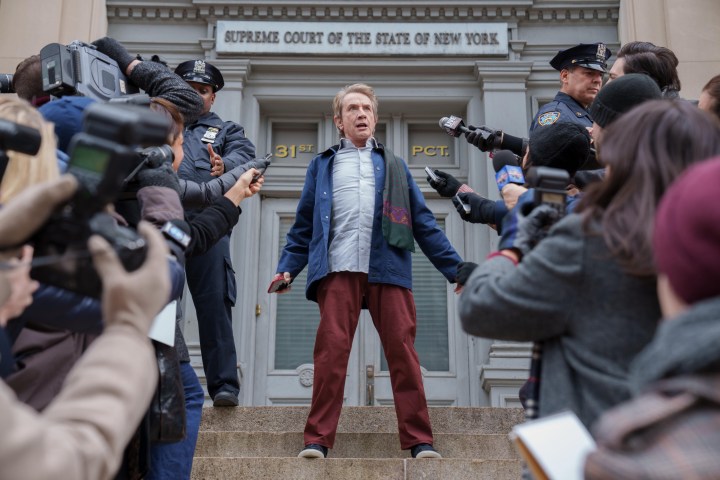 Оливер Патнэм стоит перед толпой репортеров во втором сезоне сериала «Только убийства в здании».