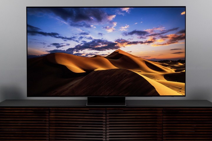 A beautiful sunset behind sand dunes is shown on the Samsung S95B OLED TV.