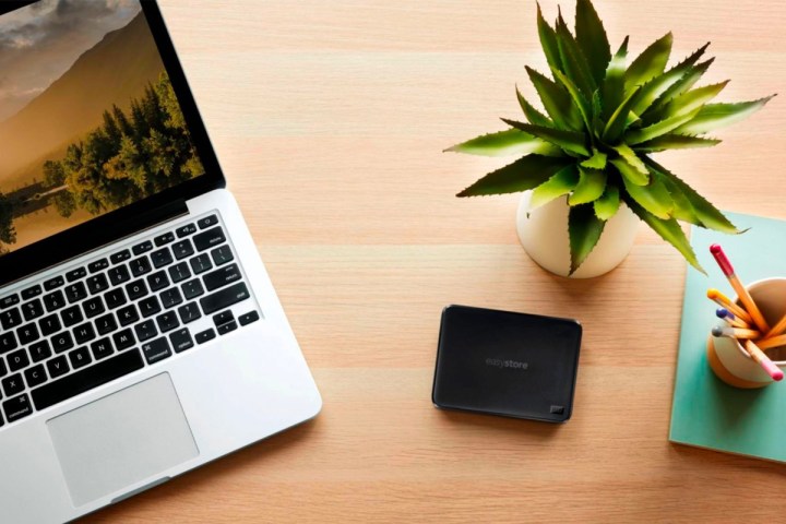 A WD Easystore external hard drive next to a MacBook Pro.