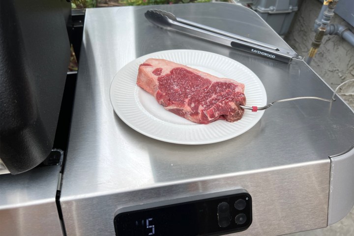 A pork tenderloin with a probe from the Weber Genesis Smart Grill plugged in.