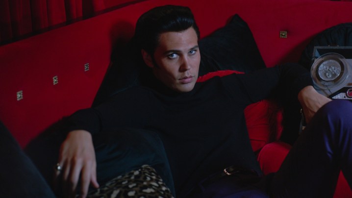 Austin Butler lounges on a red couch in Elvis.