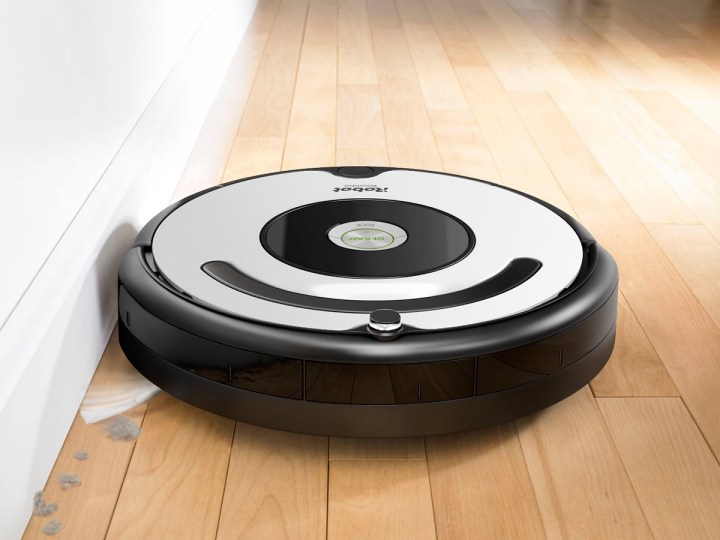An iRobot Roomba 670 robot vacuum picks up dust on a hardwood floor.