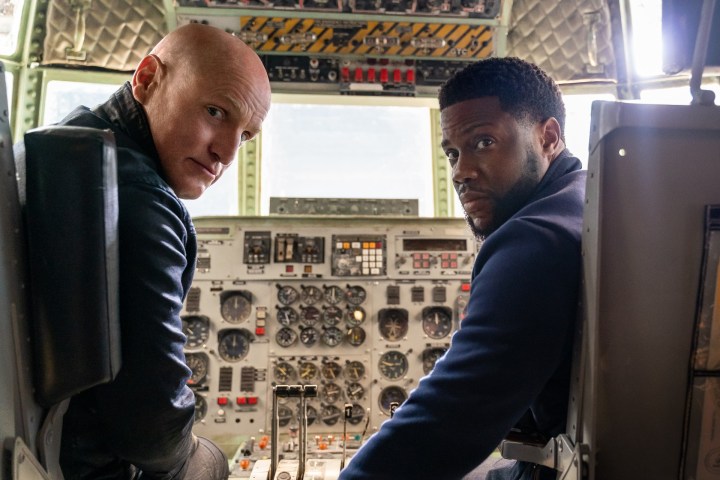Kevin Hart and Woody Harrelson sit next to each other in The Man from Toronto.