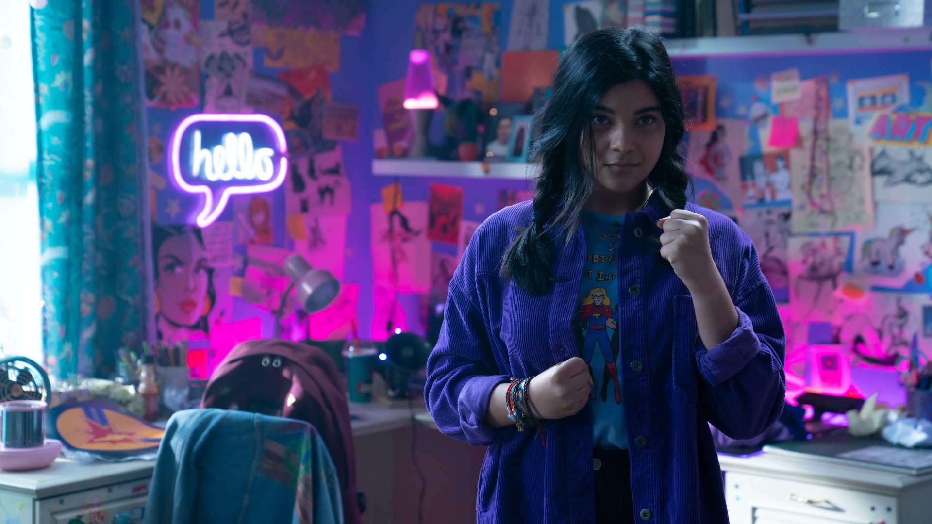 Iman Vellani como Kamala Khan está em seu quarto, fechando o punho, em uma cena de Ms. Marvel.