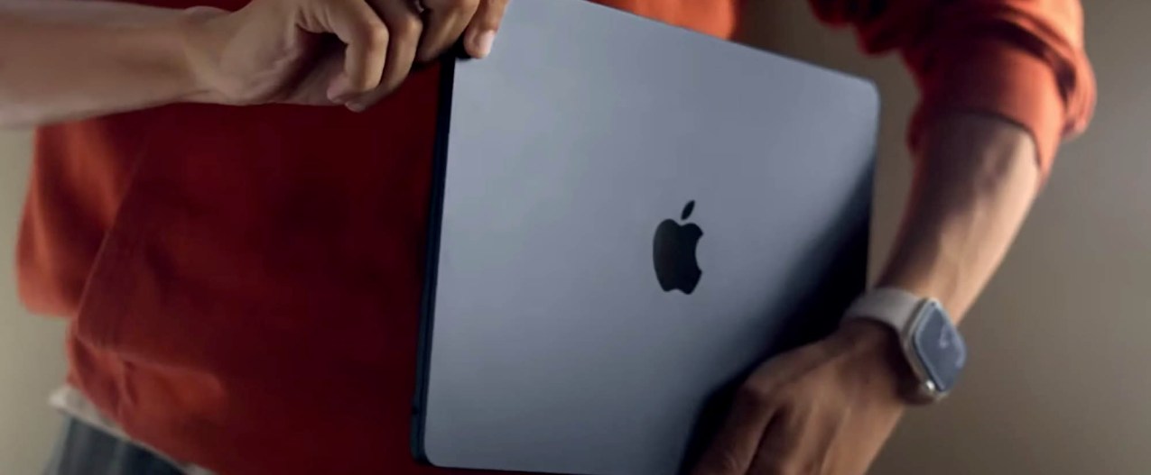 A man holds the new Macbook Air (2022) in his hands.