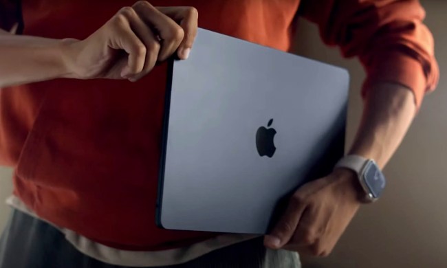 A man holds the new Macbook Air (2022) in his hands.