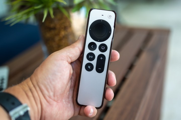 Person holding apple TV remote in their hand. 