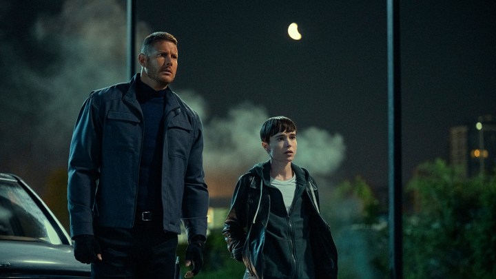 Tom Hopper and Elliot Page as Luther and Viktor standing on the street at night in The Umbrella Academy season 3.