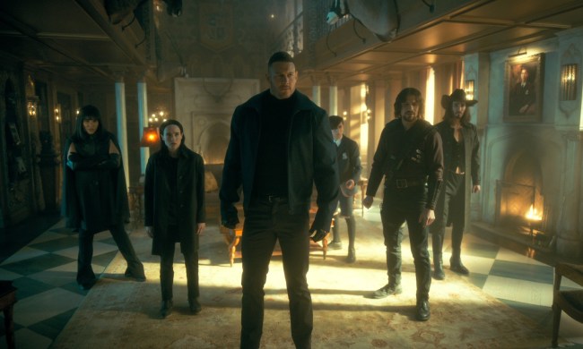 The cast of The Umbrella Academy stands together in the main room of the family mansion.
