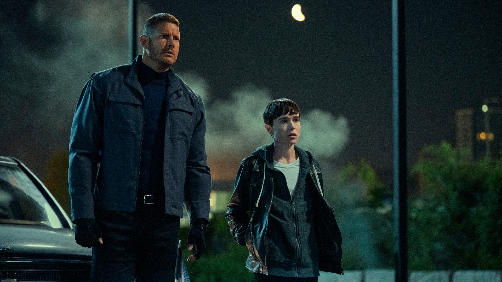 Tom Hopper y Elliot Page están uno al lado del otro en una escena de la tercera temporada de The Umbrella Academy.
