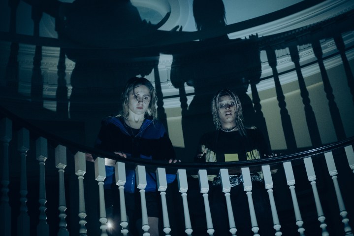 Bee and Sophie look over a bannister together in Bodies Bodies Bodies.