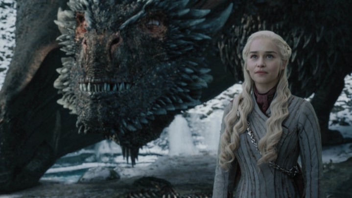 Daenerys Targaryen with Drogon behind her in Game of Thrones.