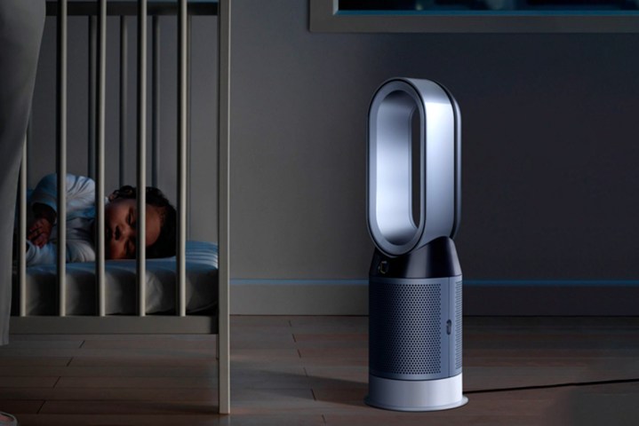Dyson's Pure Hot + Cool Smart Air Purifier sits on the ground next to a sleeping baby in its crib.