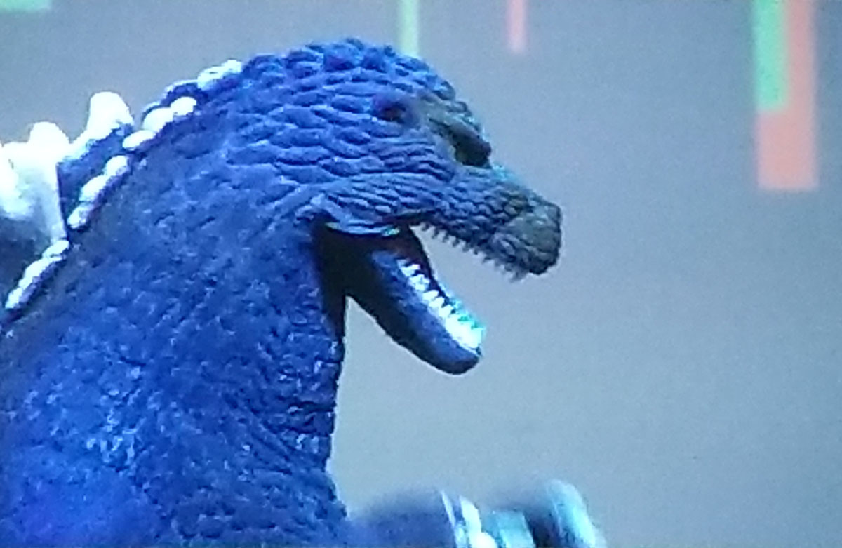 Un primer plano del cosplay de Godzilla.