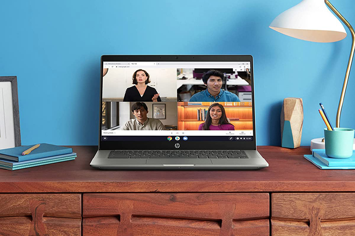 HP Chromebook 14b एक डेस्क पर बैठा है।