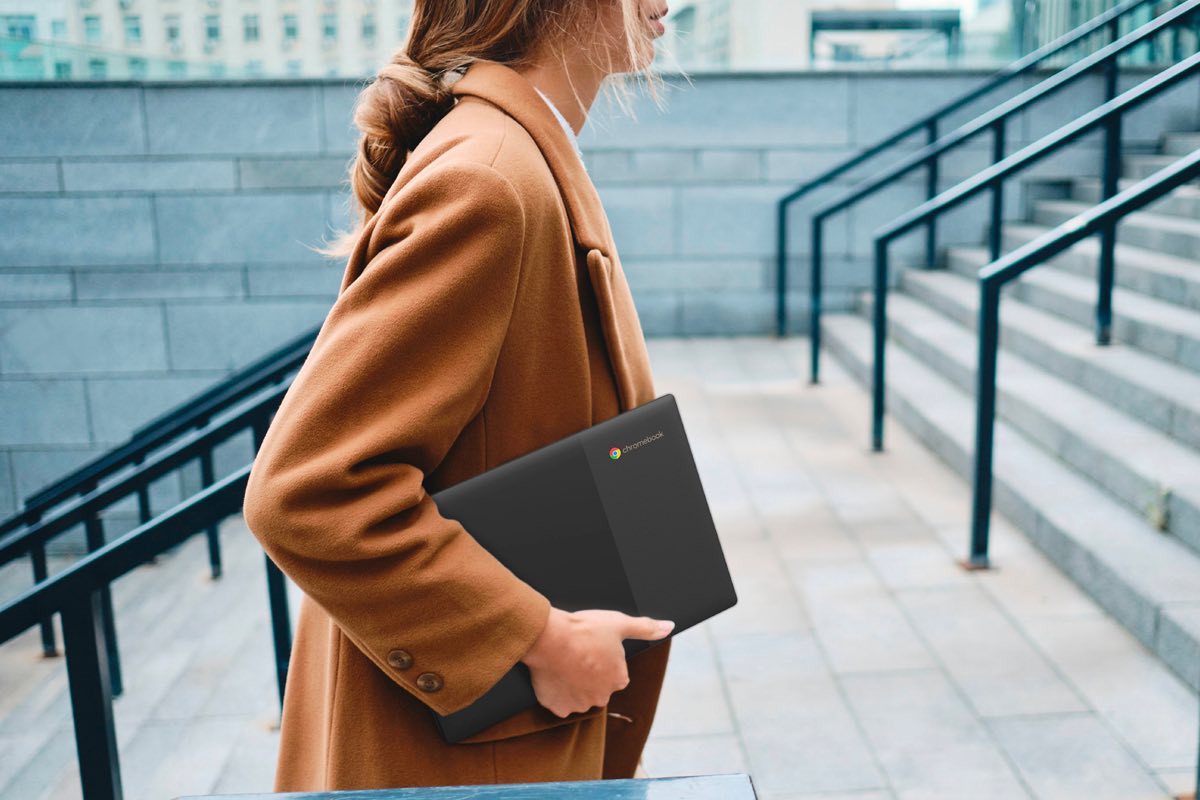 A young woman carries her Lenovo Chromebook 3 up a flight of stairs.