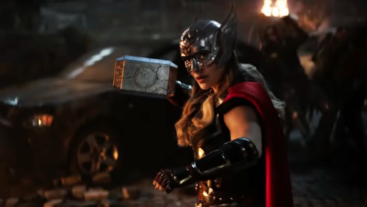 Natalie Portman in costume as Might Thor and wielding Mjolnir in Love and Thunder.