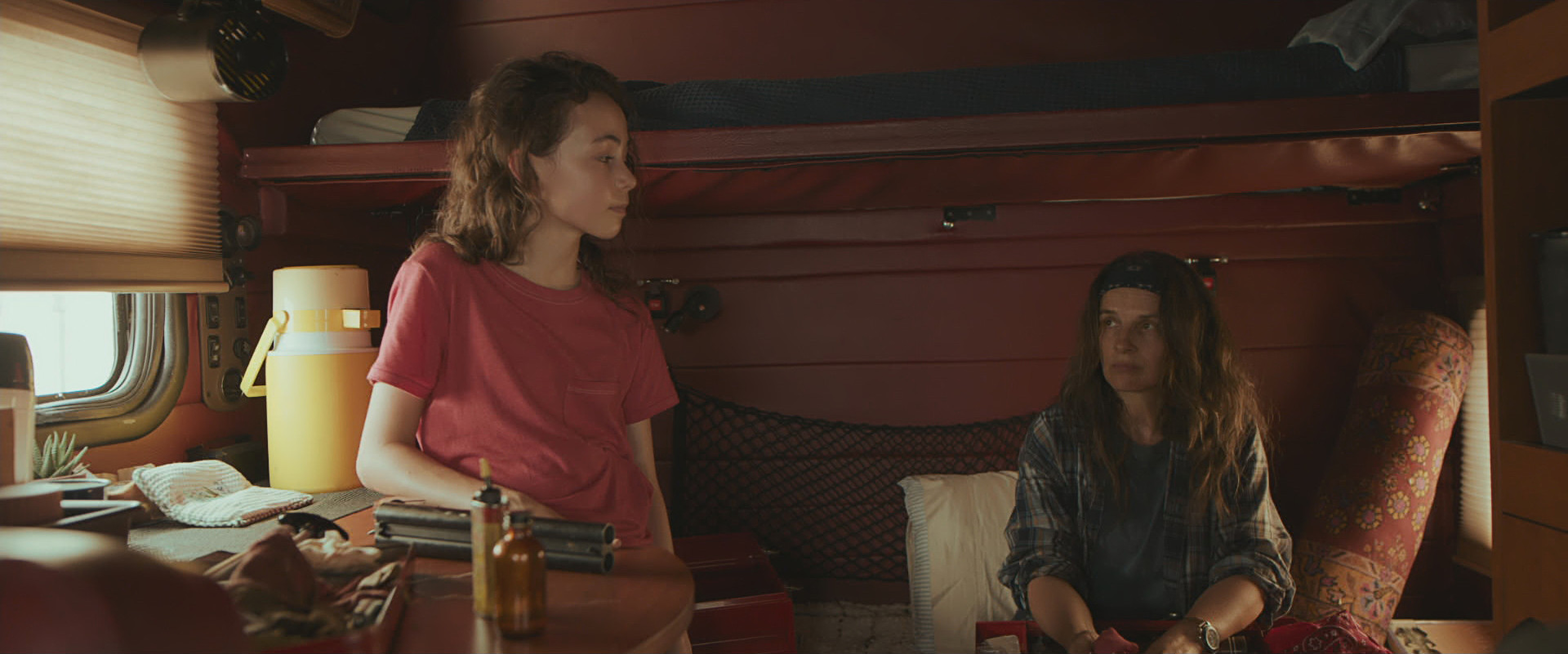 Hala Finley y Juliette Binoche se miran y hablan en el camión en una escena de Paradise Highway. 