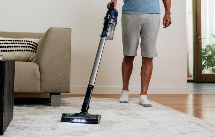 A man cleaning the home using the Shark Cordless Pet Stick Vacuum.