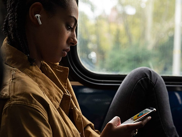 Woman wearing AirPods Pro wireless earbuds on a train.