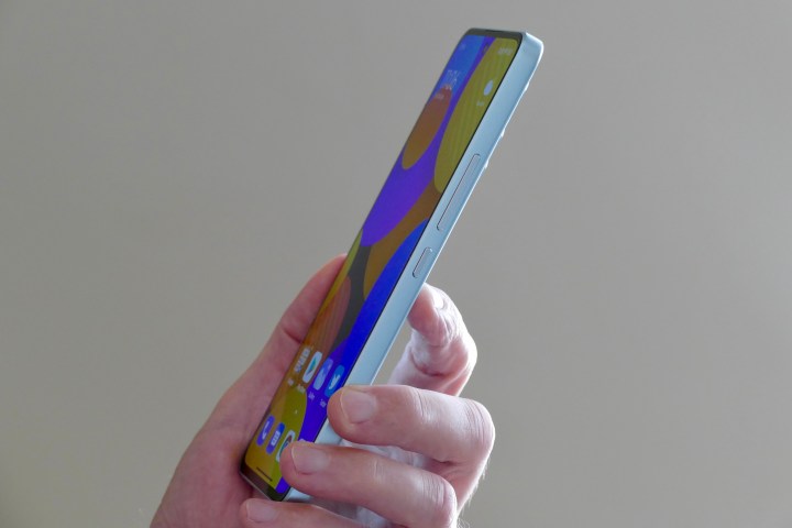 Il lato dello Xiaomi 12 Lite, tenuto in mano da un uomo.