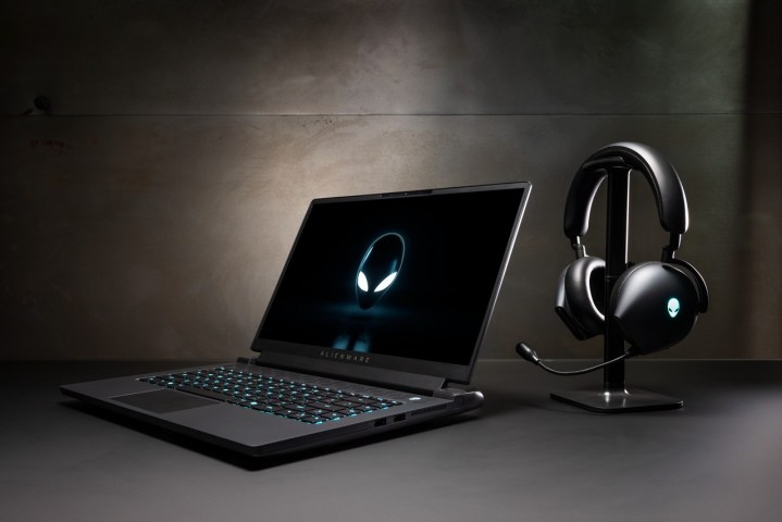Alienware m17 R5 laptop sitting adjacent  to a headset.