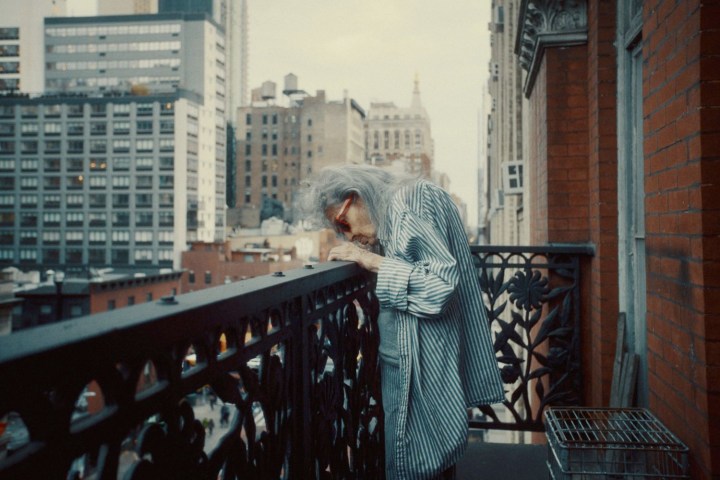 Seorang wanita mengintip dari balkon di Dreaming Walls.