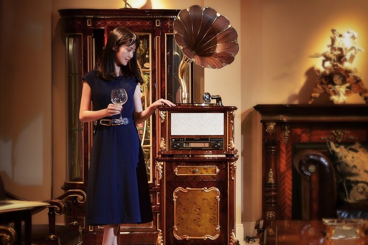 Wanita berdiri di samping gramofon Fennessy klasik.