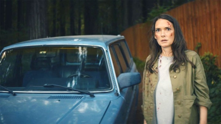 Вайнона Райдер стоит рядом с синей машиной в фильме «Унесенные ночью».