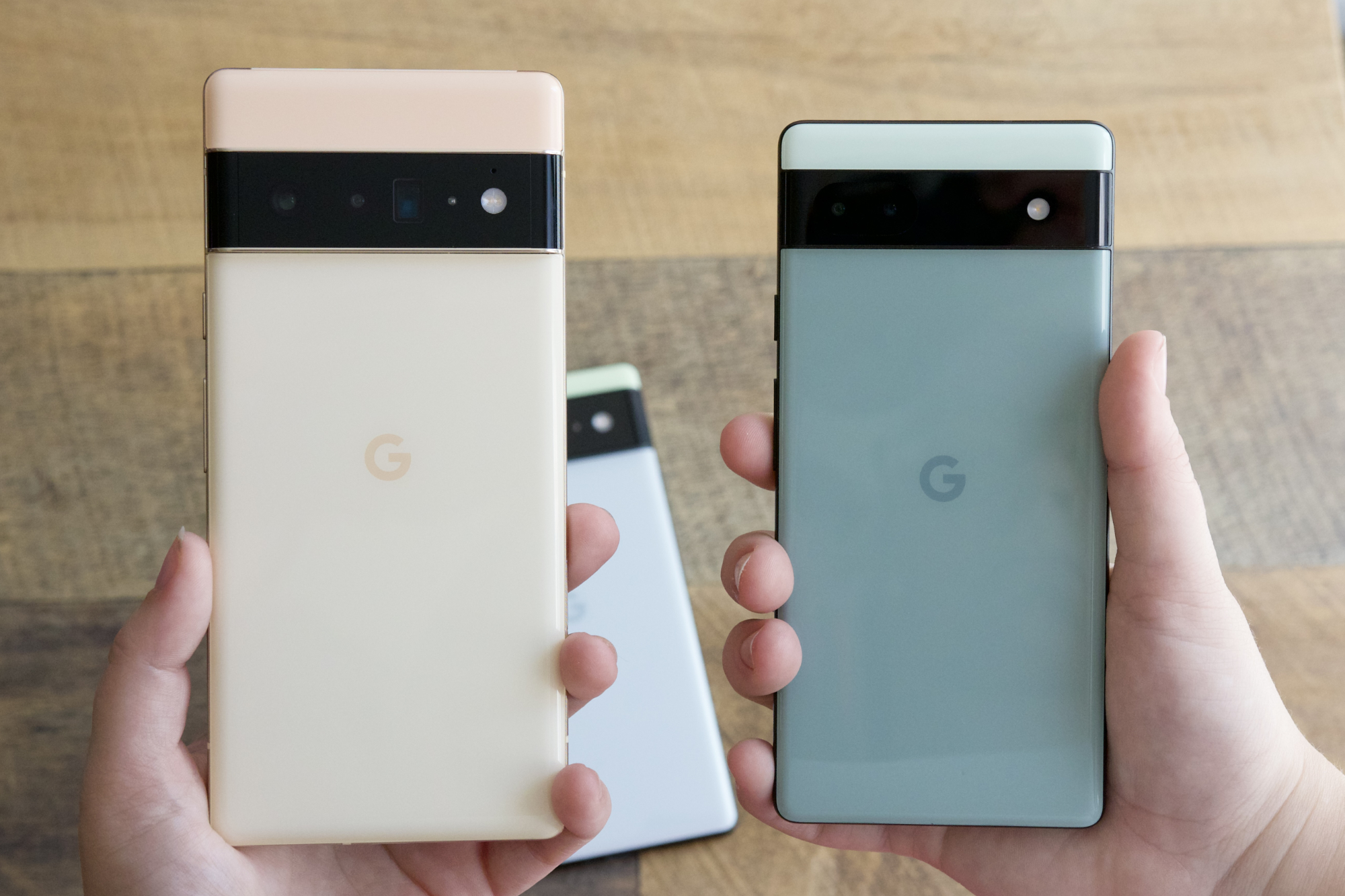 Alguém segurando o Google Pixel 6 Pro e o Pixel 6a um ao lado do outro.