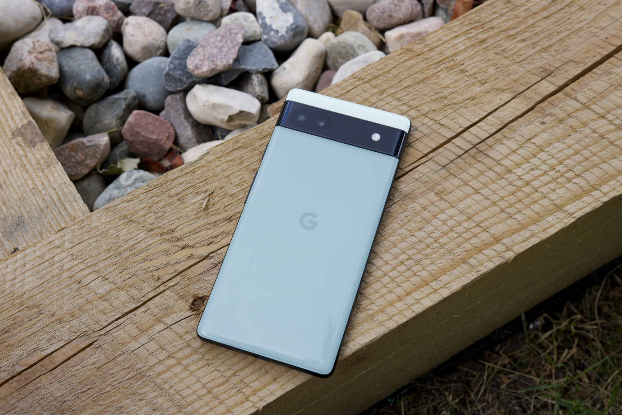 El Google Píxel 6a. Vemos la parte posterior del teléfono colocada encima de un trozo de madera.