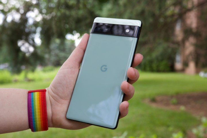 Someone outside holding the Pixel 6a. We see the back of the phone.