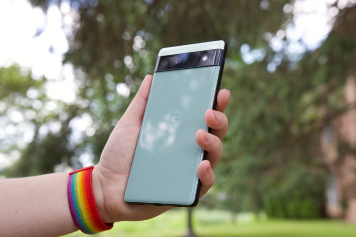 Someone outside holding the Pixel 6a.  We see the back of the phone.