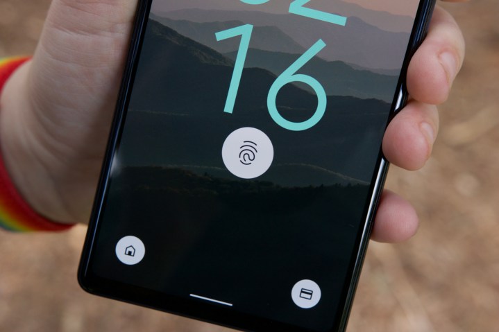A close-up shot of the Google Pixel 6a. The display is turned on and showing the fingerprint sensor icon.