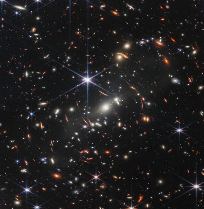 This first image from NASA’s James Webb Space Telescope is the deepest and sharpest infrared image of the distant universe to date. Known as Webb’s First Deep Field, this image of galaxy cluster SMACS 0723 is overflowing with detail. Thousands of galaxies – including the faintest objects ever observed in the infrared – have appeared in Webb’s view for the first time. This slice of the vast universe covers a patch of sky approximately the size of a grain of sand held at arm’s length by someone on the ground.