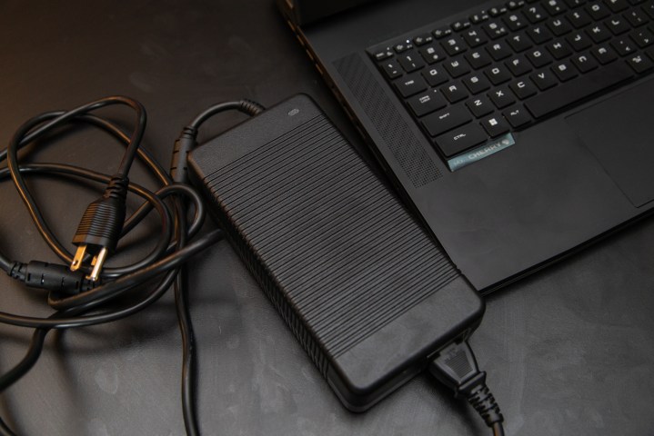 MSI GT77 Titan power brick seduto accanto al laptop.