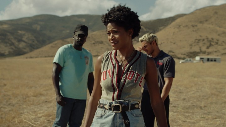 Keke Palmer stand sin front of Daniel Kaluuya and Brandon Perea on a long dirt road in a scene from Nope.