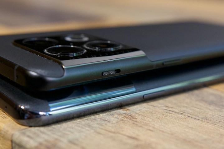 OnePlus 10T و OnePlus 10 Pro روی یک میز چوبی در کنار یکدیگر دراز کشیده اند.