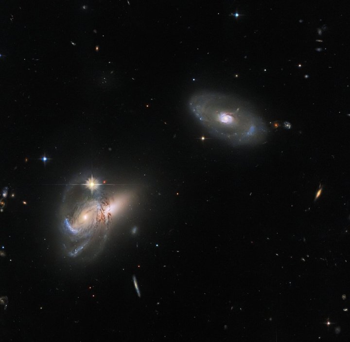 This luminescent image features multiple galaxies, perhaps most noticeably LEDA 58109, the lone galaxy in the upper right, flanked by two further galactic objects to its lower left.